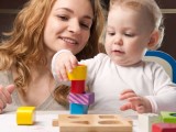 Mother and baby daughter building tower